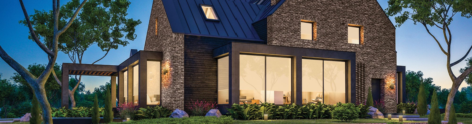 A modern home at dusk with warm interior and landscape lighting